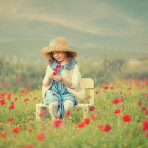 גלויה של ילדה מתולתלת עם פרחים אדומים